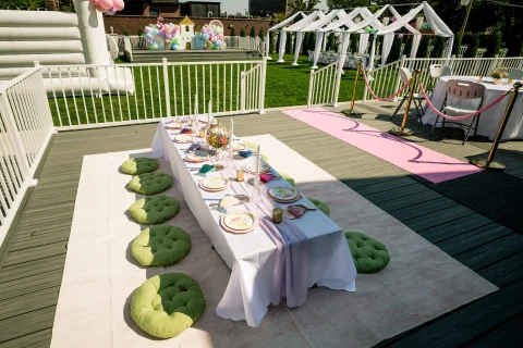 Place settings for children and green pillows seating on the deck at Barker Cottage.