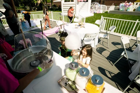 Child is served cotton candy outside during a party at the Barker Cottage.